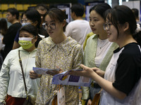 Job seekers are looking for a suitable position at a job fair held by industrial reform enterprises in Huai'an, China, on June 2, 2024. (