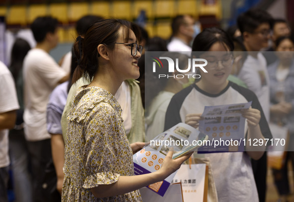 Job seekers are looking for a suitable position at a job fair held by industrial reform enterprises in Huai'an, China, on June 2, 2024. 