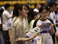 Job seekers are looking for a suitable position at a job fair held by industrial reform enterprises in Huai'an, China, on June 2, 2024. (