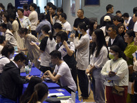 Job seekers are looking for a suitable position at a job fair held by industrial reform enterprises in Huai'an, China, on June 2, 2024. (