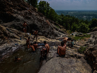 Kashmir boys are taking a bath at a waterfall on a mountain in Hajin, Bandipora, Jammu and Kashmir, India, on June 2, 2024. 61 people are dy...