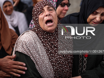 Palestinians are mourning the death of their relatives in an Israeli strike at the Al-Aqsa Martyrs Hospital in Deir al-Balah in the central...