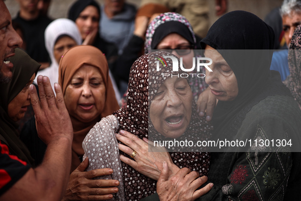 Palestinians are mourning the death of their relatives in an Israeli strike at the Al-Aqsa Martyrs Hospital in Deir al-Balah in the central...