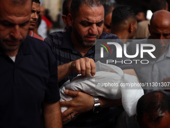 Palestinians are mourning their relatives, killed by an Israeli army strike the previous night, during a funeral at the Al-Aqsa Martyrs Hosp...