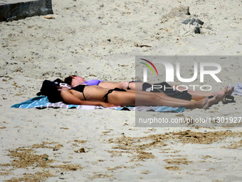 People are relaxing on the beach next to a newly opened bomb shelter in Odesa, Ukraine, on May 31, 2024. NO USE RUSSIA. NO USE BELARUS. (