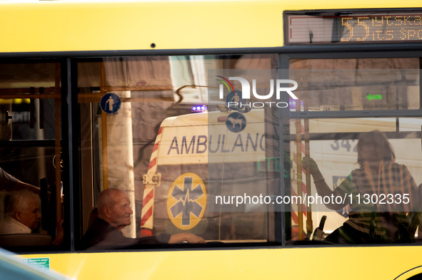 An ambulance is being reflected in a bus window in Kyiv, Ukraine, on June 3, 2024. NO USE RUSSIA. NO USE BELARUS. 