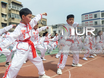 Students are practicing martial arts during a class break at the Second Experimental Primary School in Guanyun County, Lianyungang city, in...