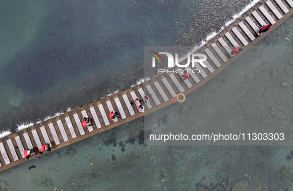 Volunteers are picking up debris at the Black Dragon Cave Scenic spot in Handan, China, on June 4, 2024. 