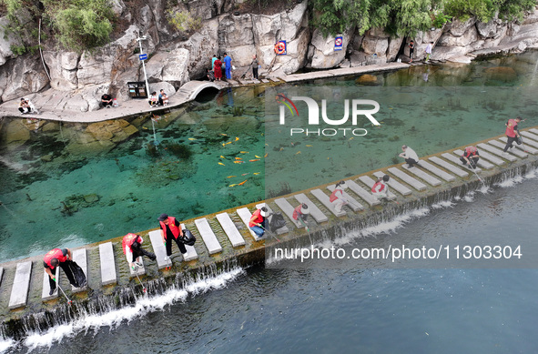 Volunteers are picking up debris at the Black Dragon Cave Scenic spot in Handan, China, on June 4, 2024. 