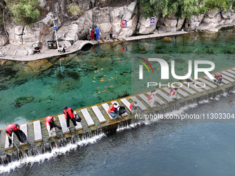 Volunteers are picking up debris at the Black Dragon Cave Scenic spot in Handan, China, on June 4, 2024. (