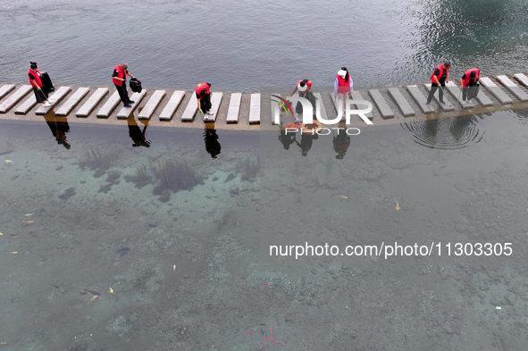 Volunteers are picking up debris at the Black Dragon Cave Scenic spot in Handan, China, on June 4, 2024. 