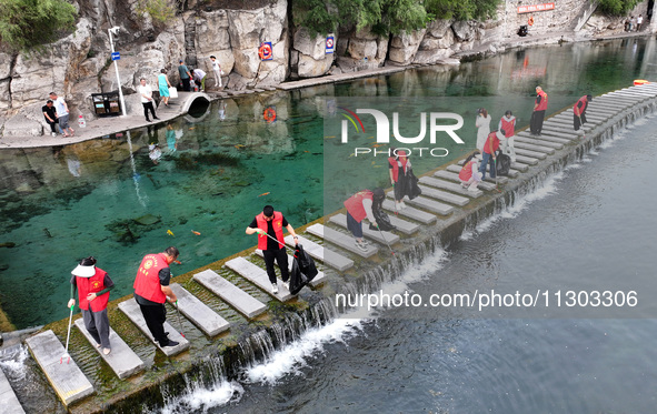 Volunteers are picking up debris at the Black Dragon Cave Scenic spot in Handan, China, on June 4, 2024. 