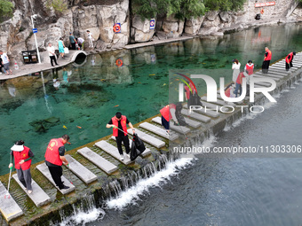 Volunteers are picking up debris at the Black Dragon Cave Scenic spot in Handan, China, on June 4, 2024. (