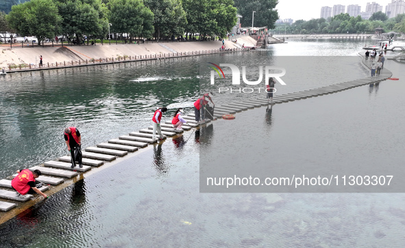 Volunteers are picking up debris at the Black Dragon Cave Scenic spot in Handan, China, on June 4, 2024. 