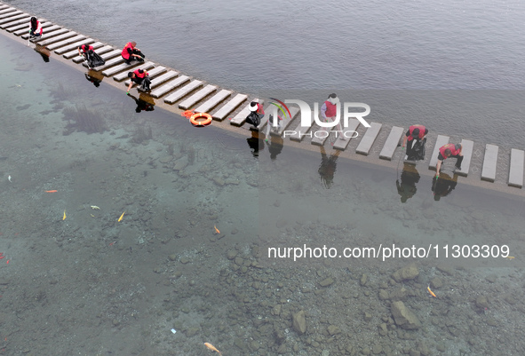 Volunteers are picking up debris at the Black Dragon Cave Scenic spot in Handan, China, on June 4, 2024. 