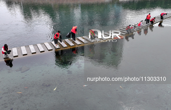 Volunteers are picking up debris at the Black Dragon Cave Scenic spot in Handan, China, on June 4, 2024. 