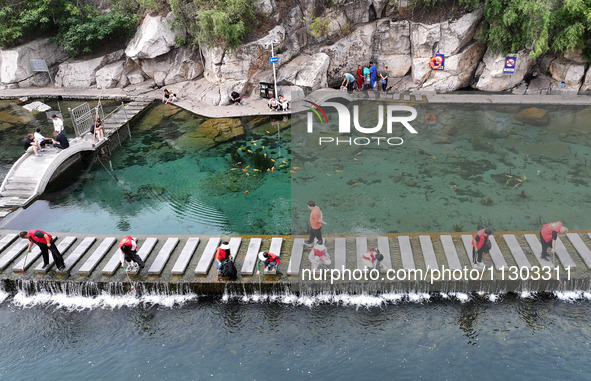 Volunteers are picking up debris at the Black Dragon Cave Scenic spot in Handan, China, on June 4, 2024. 