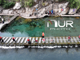 Volunteers are picking up debris at the Black Dragon Cave Scenic spot in Handan, China, on June 4, 2024. (