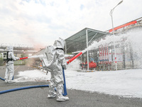 Personnel are cooling down a burning storage tank during an emergency drill for handling a dangerous chemical leak fire in Deqing county, Hu...