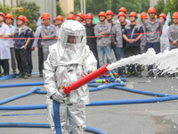 Personnel are cooling down a burning storage tank during an emergency drill for handling a dangerous chemical leak fire in Deqing county, Hu...