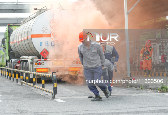 A company's emergency personnel are transferring the injured during a fire emergency drill in Deqing County, Huzhou city, Zhejiang province,...