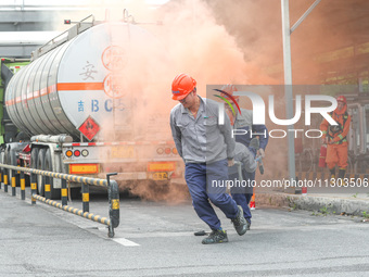 A company's emergency personnel are transferring the injured during a fire emergency drill in Deqing County, Huzhou city, Zhejiang province,...