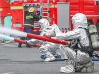 Personnel are cooling down a burning storage tank during an emergency drill for handling a dangerous chemical leak fire in Deqing county, Hu...