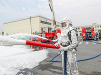 Personnel are cooling down a burning storage tank during an emergency drill for handling a dangerous chemical leak fire in Deqing county, Hu...