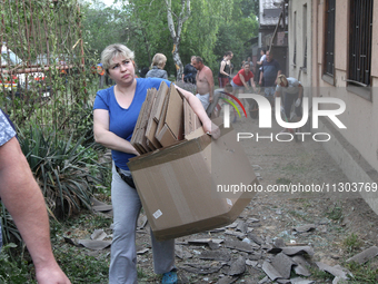 People are removing the debris following a nighttime Russian missile strike in Dnipro, Ukraine, on June 4, 2024. Ukraine's air defense force...