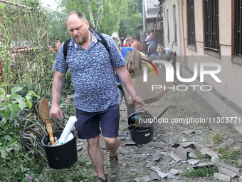 People are removing the debris following a nighttime Russian missile strike in Dnipro, Ukraine, on June 4, 2024. Ukraine's air defense force...