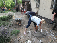 People are removing the debris following a nighttime Russian missile strike in Dnipro, Ukraine, on June 4, 2024. Ukraine's air defense force...