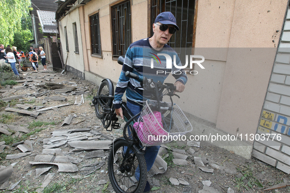 A man is carrying a salvaged bicycle following a nighttime Russian missile attack in Dnipro, Ukraine, on June 4, 2024. As reported by Ukrinf...