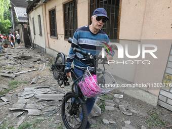 A man is carrying a salvaged bicycle following a nighttime Russian missile attack in Dnipro, Ukraine, on June 4, 2024. As reported by Ukrinf...