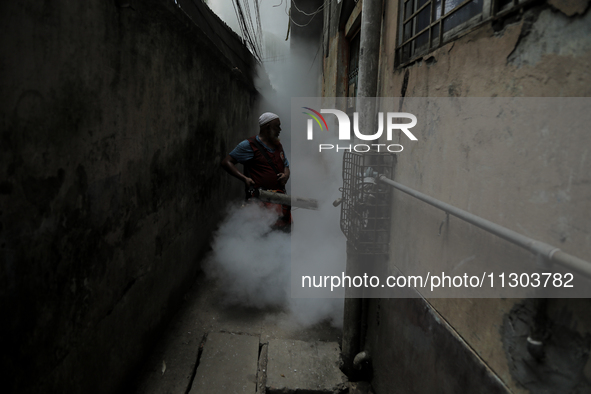 A municipal worker from the Department of Health Service is fumigating vapor to stem the spread of dengue in Dhaka, Bangladesh, on June 4, 2...