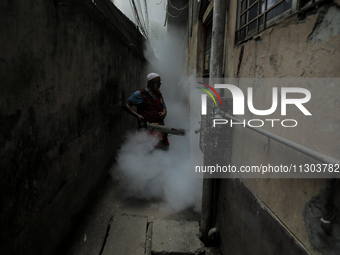 A municipal worker from the Department of Health Service is fumigating vapor to stem the spread of dengue in Dhaka, Bangladesh, on June 4, 2...