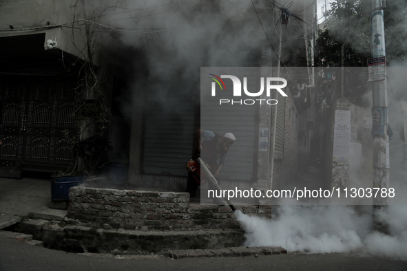 A municipal worker from the Department of Health Service is fumigating vapor to stem the spread of dengue in Dhaka, Bangladesh, on June 4, 2...