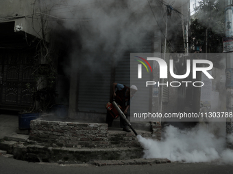 A municipal worker from the Department of Health Service is fumigating vapor to stem the spread of dengue in Dhaka, Bangladesh, on June 4, 2...