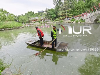 Volunteers are cleaning up floating objects on a river in Qingzhou, China, on June 5, 2024. (