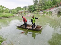 Volunteers are cleaning up floating objects on a river in Qingzhou, China, on June 5, 2024. (