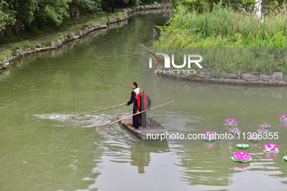 Volunteers are cleaning up floating objects on a river in Qingzhou, China, on June 5, 2024. 