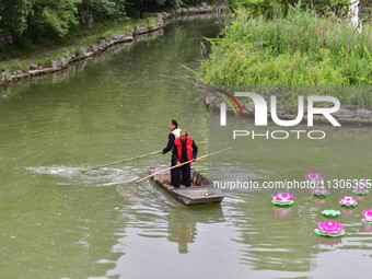 Volunteers are cleaning up floating objects on a river in Qingzhou, China, on June 5, 2024. (