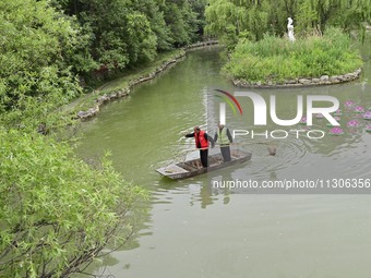 Volunteers are cleaning up floating objects on a river in Qingzhou, China, on June 5, 2024. (