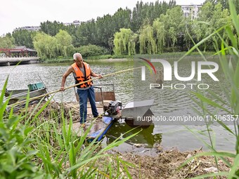 Volunteers are cleaning up floating objects on a river in Qingzhou, China, on June 5, 2024. (