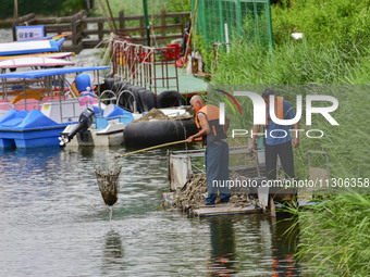 Volunteers are cleaning up floating objects on a river in Qingzhou, China, on June 5, 2024. (