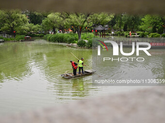 Volunteers are cleaning up floating objects on a river in Qingzhou, China, on June 5, 2024. (