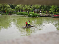 Volunteers are cleaning up floating objects on a river in Qingzhou, China, on June 5, 2024. (