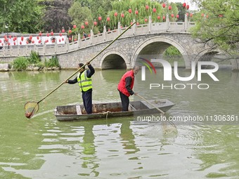 Volunteers are cleaning up floating objects on a river in Qingzhou, China, on June 5, 2024. (