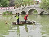 Volunteers are cleaning up floating objects on a river in Qingzhou, China, on June 5, 2024. (