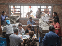 Silkworm farmers are selling silkworm cocoons at a silkworm cocoon buying point in Hai'an, China, on June 4, 2024. (