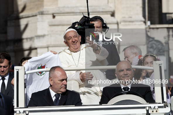 Pope Francis is waving as he is arriving to lead the weekly general audience in Saint Peter's Square, Vatican City, on June 5, 2024. 